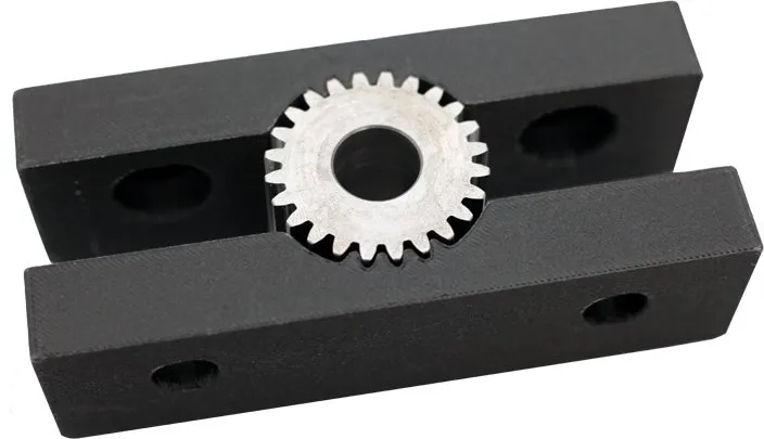 Black Rizium CF soft vise jaws holding a steel gear
